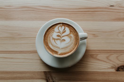 Top view of a cup of latte with beautiful latte art on a wooden table.